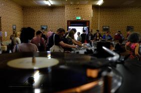 Stalls at a record fair with people milling around and crate-digging